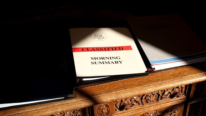 A single sealed envelope resting on a counter beside a wall clock showing the hour, in a plain office corridor.